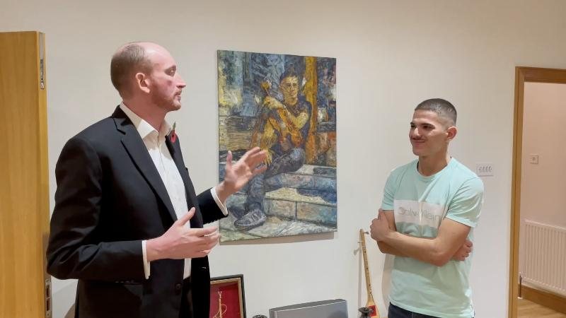 Arnold Broqi with HM Ambassador Alastair King-Smith in front of his painting